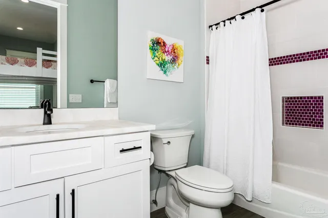 a bedroom with a bed and flat tv screen on the dresser