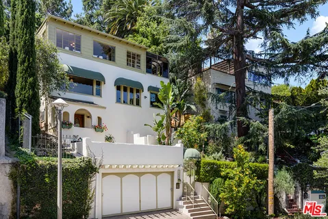 a front view of a house with a garden