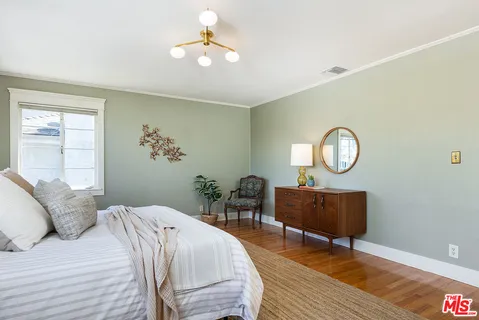 a bed room with a bed mirror and a window