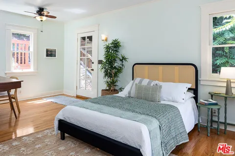 a bedroom with a large bed chandelier and a window