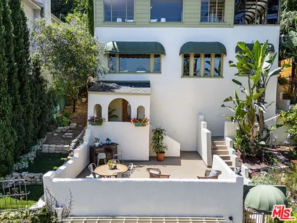 a white building with couches and potted plants