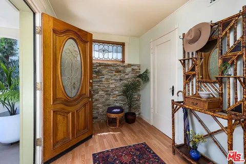 a view of a hallway with entryway wooden floor and front door
