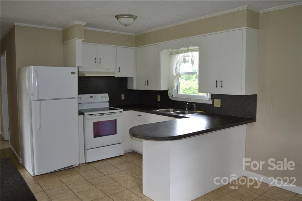 2751 Lail Road Morganton, NC 28655 - Photo 18 of 32 a kitchen with stainless steel appliances granite countertop a sink stove and refrigerator