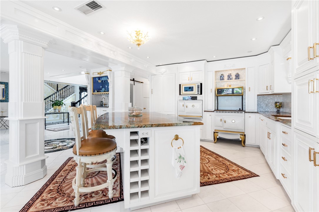 15910 El Soccorro Loop Corpus Christi, TX 78418 - Photo 14 of 40 a kitchen with stainless steel appliances kitchen island granite countertop a stove a sink a refrigerator and white cabinets with wooden floor