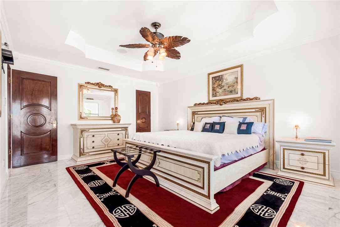 15910 El Soccorro Loop Corpus Christi, TX 78418 - Photo 27 of 40 a bedroom with a bed and a chandelier