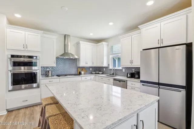 a kitchen with stainless steel appliances granite countertop a sink stove and refrigerator