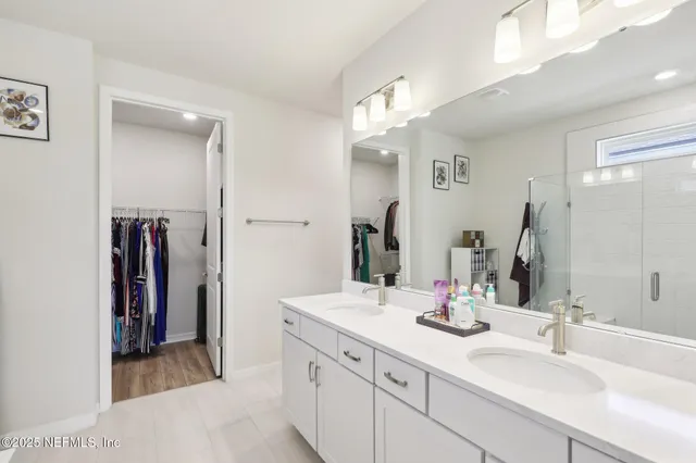 a bathroom with a double vanity sink mirror double and shower