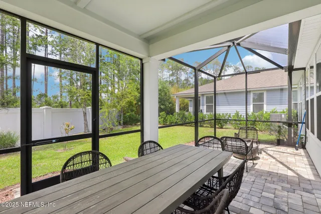 a view of a patio with a table chairs and a backyard
