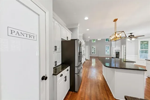 a kitchen with granite countertop a sink cabinets stainless steel appliances and a center island