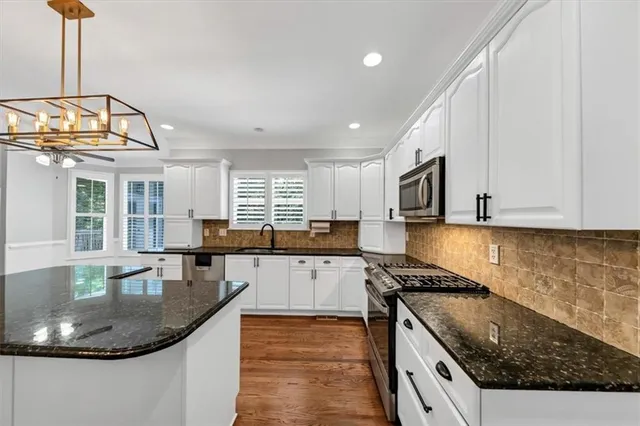 a kitchen with stainless steel appliances a sink a stove and cabinets