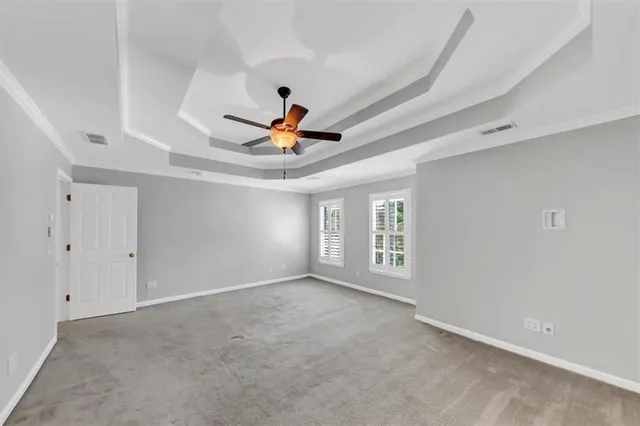 a white building with a big yard and large trees