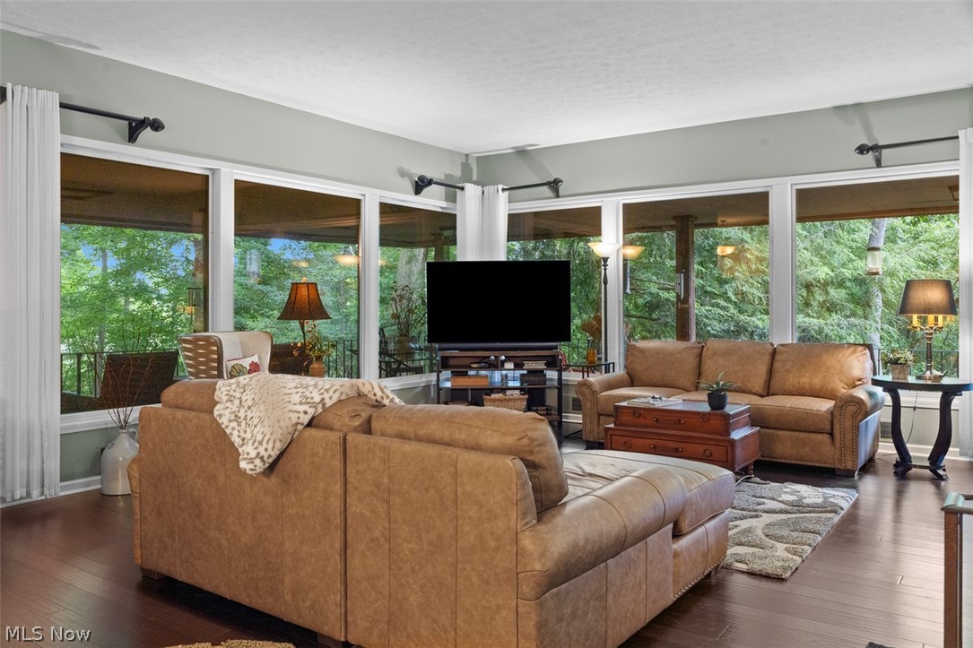 171 Granger Road, Unit 107 Medina, OH 44256 - Photo 13 of 41 Great room featuring expansive windows, dark Bamboo wood flooring, light grey wall tones, white crown molding, and a wrap around outdoor deck covered.