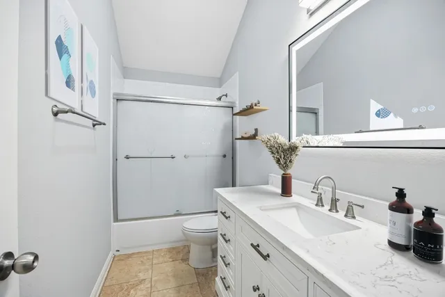 a bathroom with a granite countertop sink a toilet and a mirror