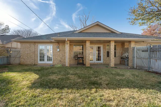 a view of a patio with table and chairs and wooden fence