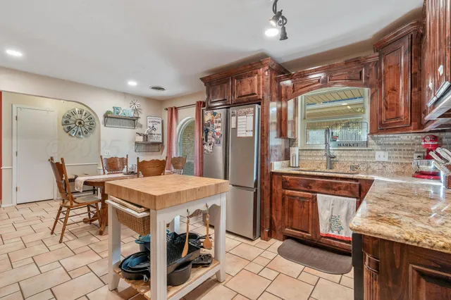 a kitchen with stainless steel appliances granite countertop a sink a stove and a refrigerator