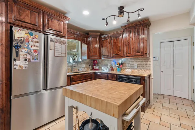 a kitchen with stainless steel appliances granite countertop a sink a stove and cabinets
