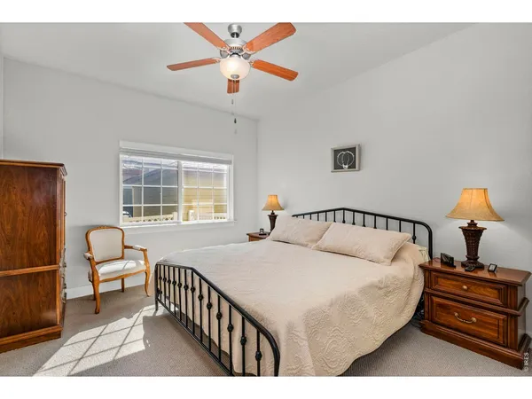 a bedroom with a bed a chandelier and dresser
