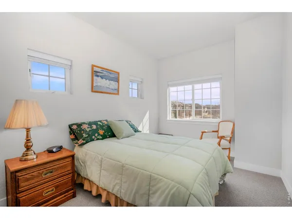 a bedroom with a bed and a lamp on dresser