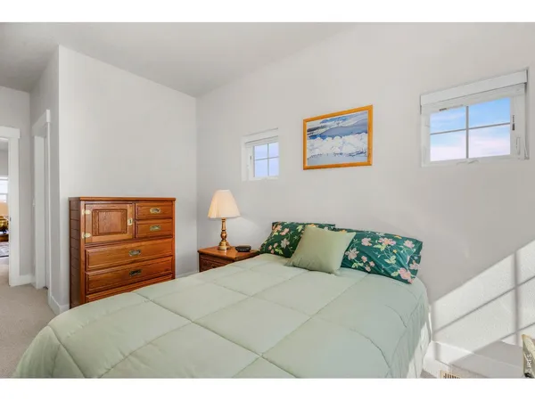 a bedroom with a bed a dresser and a window