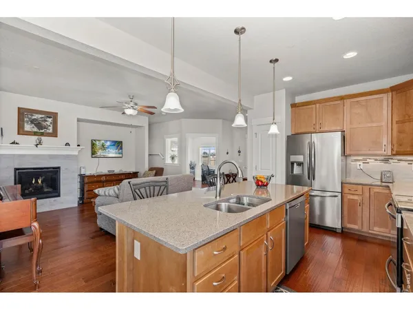 a kitchen with kitchen island granite countertop a sink stainless steel appliances and cabinets