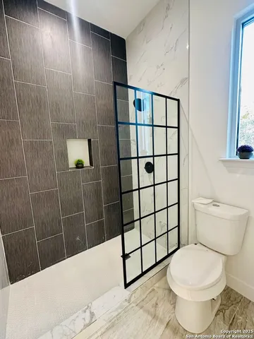 a bathroom with a toilet and a shower