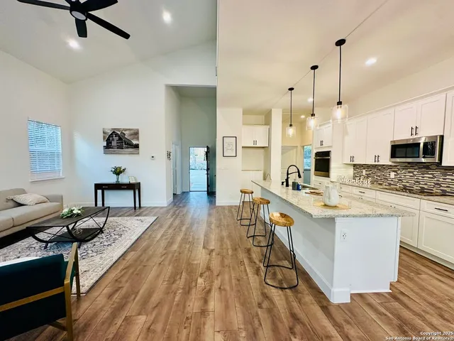 a large kitchen with kitchen island a large counter space a sink appliances and cabinets