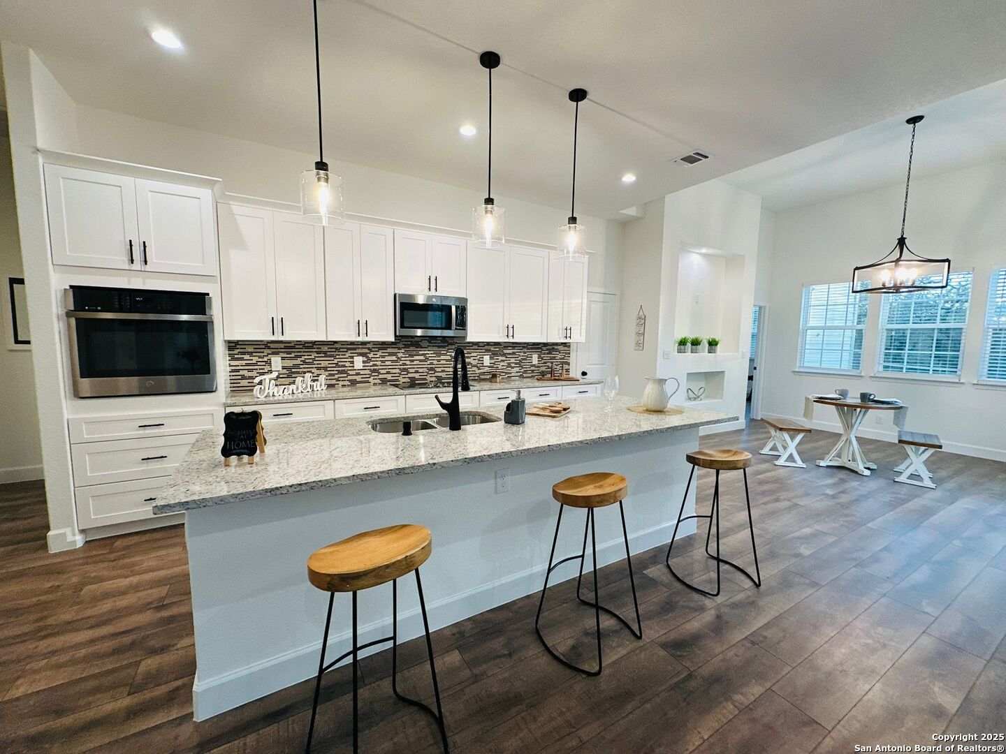 1064 Overbrook Lane Spring Branch, TX 78070 - Photo 9 of 34 a kitchen with stainless steel appliances kitchen island granite countertop a stove a sink a oven a dining table and chairs