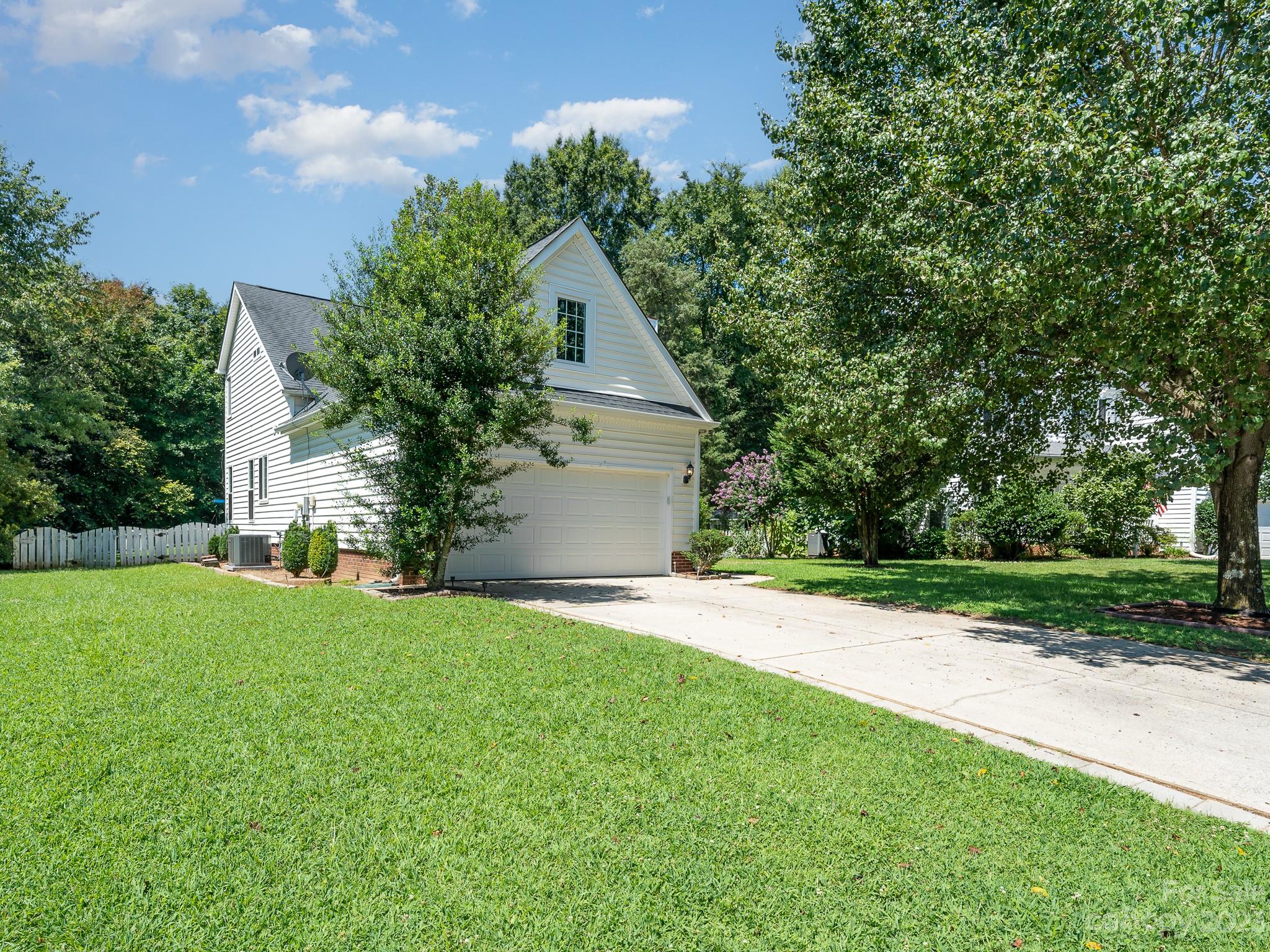 12119 Shadow Ridge Lane Charlotte, NC 28273 - Photo 2 of 28 a backyard of a house with plants and large tree