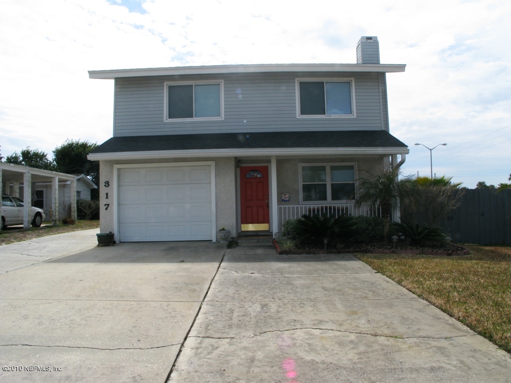 317 Magnolia Street Neptune Beach, FL 32266 - Photo 3 of 13 a front view of a house with a yard and garage