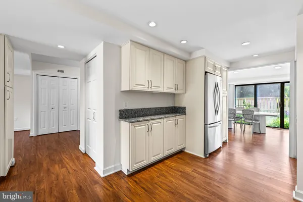 a kitchen with granite countertop a stove a sink and a refrigerator
