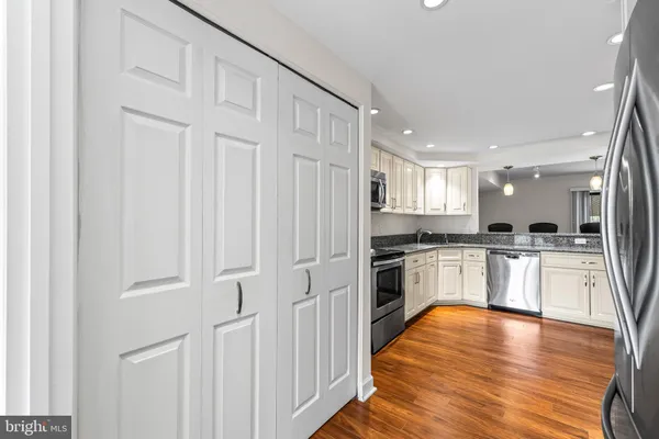 a kitchen with white cabinets and stainless steel appliances