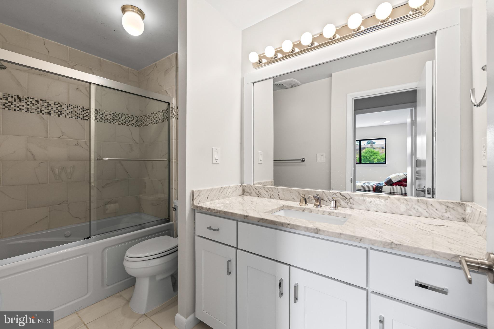 11 Tanner Court, Unit G Baltimore, MD 21208 - Photo 21 of 38 a bathroom with a granite countertop sink a toilet and shower