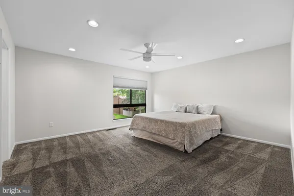 a spacious bedroom with a bed and a window
