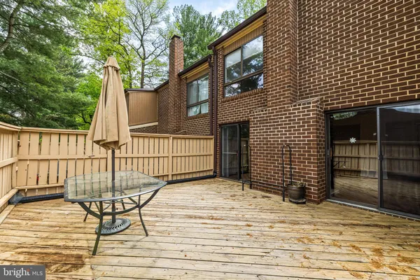 a view of a brick house with backyard and wooden fence