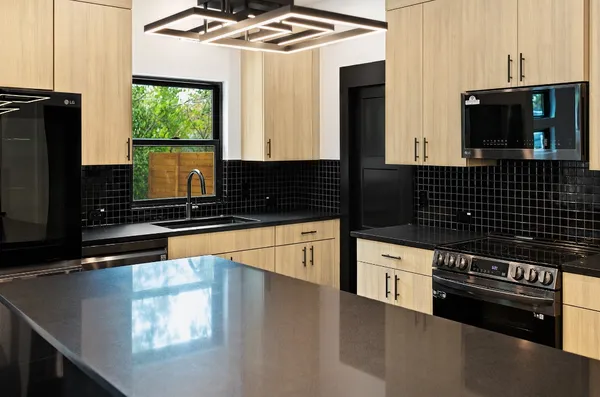 a kitchen with granite countertop a stove and a microwave