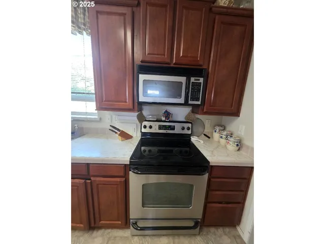 a kitchen with granite countertop wood cabinets and a stove top oven