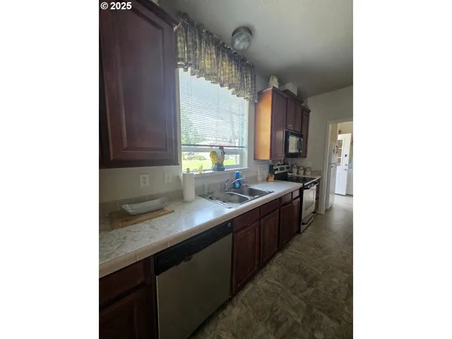 a kitchen with stainless steel appliances granite countertop a sink and cabinets