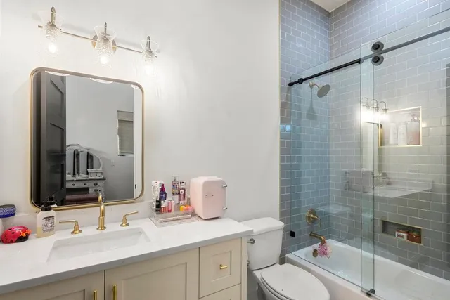 a bathroom with a sink toilet vanity and shower