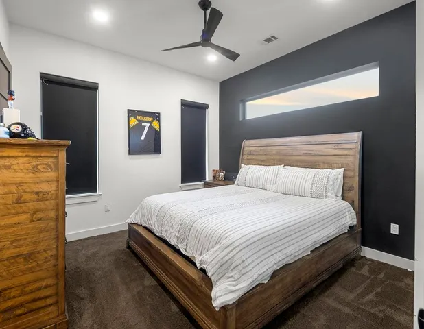 a bedroom with a bed and painting on the wall