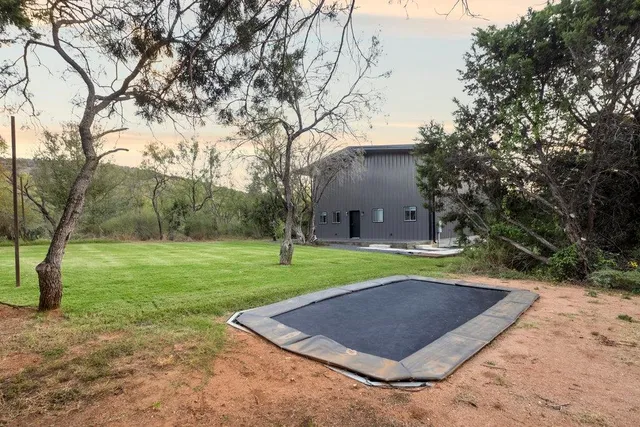 a view of a big yard with plants and trees