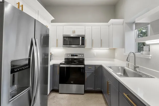 a kitchen with stainless steel appliances granite countertop a refrigerator and a sink