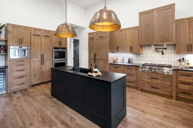 a kitchen with stainless steel appliances a stove refrigerator and cabinets