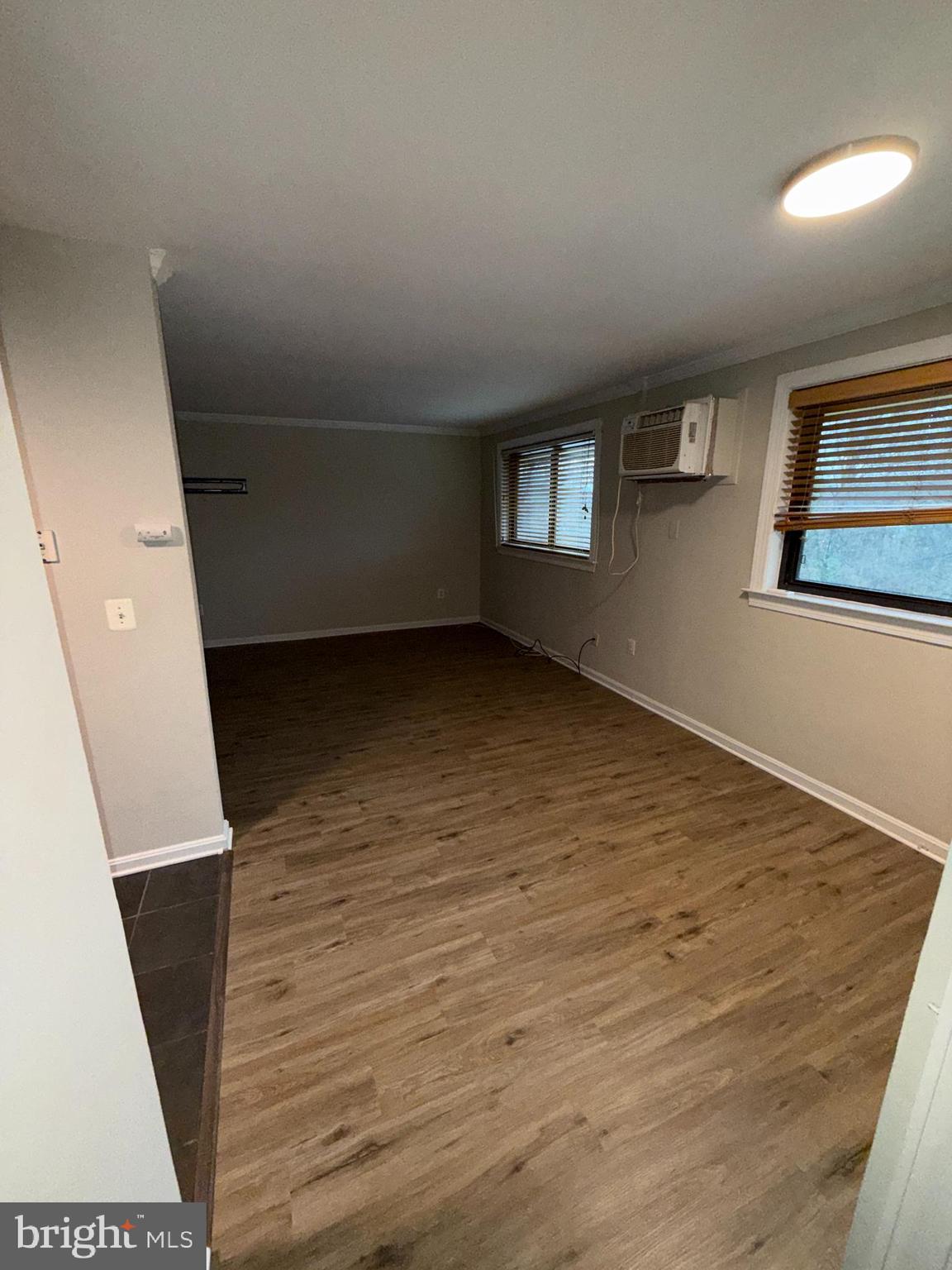 3111 Naylor Road Southeast, Unit 301 Washington, DC 20020 - Photo 11 of 11 an empty room with wooden floor and windows