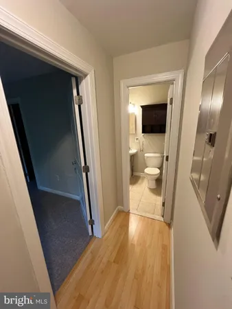 a view of a hallway with wooden floor and a living room