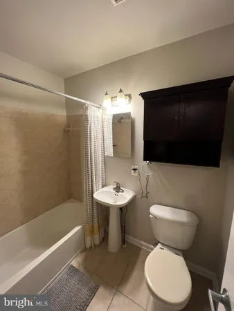a bathroom with a sink a toilet a mirror and bathtub