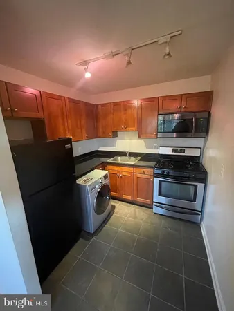 a kitchen with stainless steel appliances a stove a sink and a refrigerator