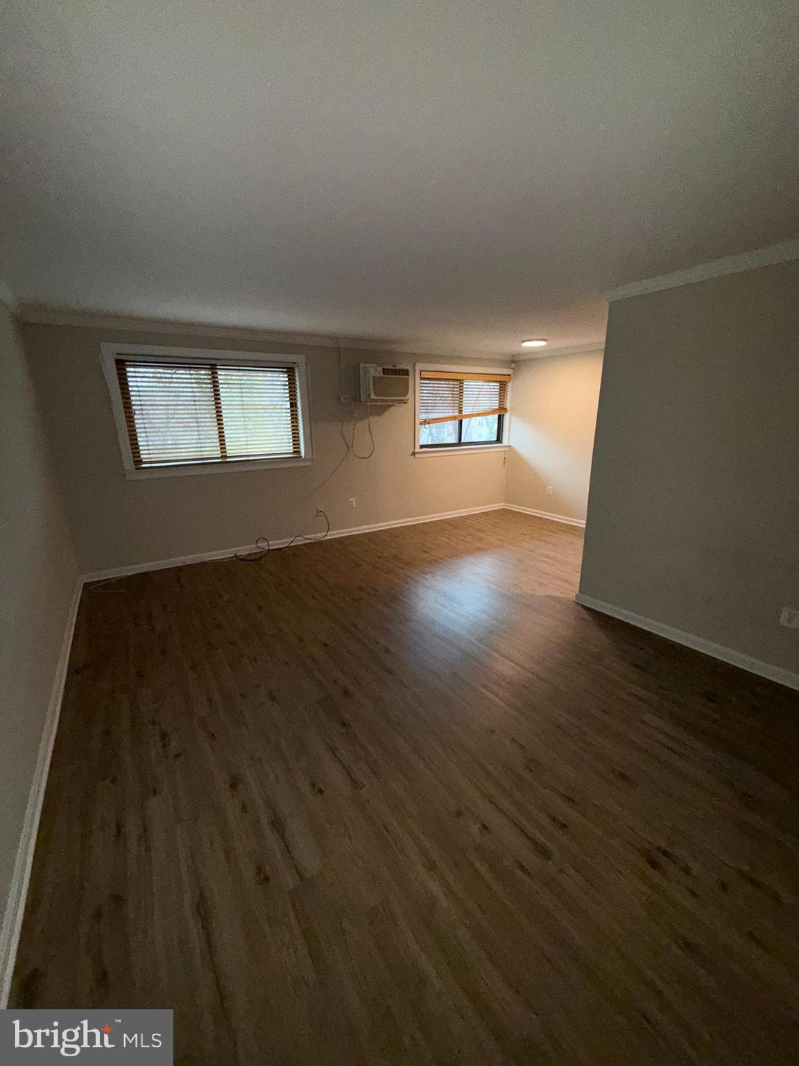 3111 Naylor Road Southeast, Unit 301 Washington, DC 20020 - Photo 10 of 11 an empty room with wooden floor and windows