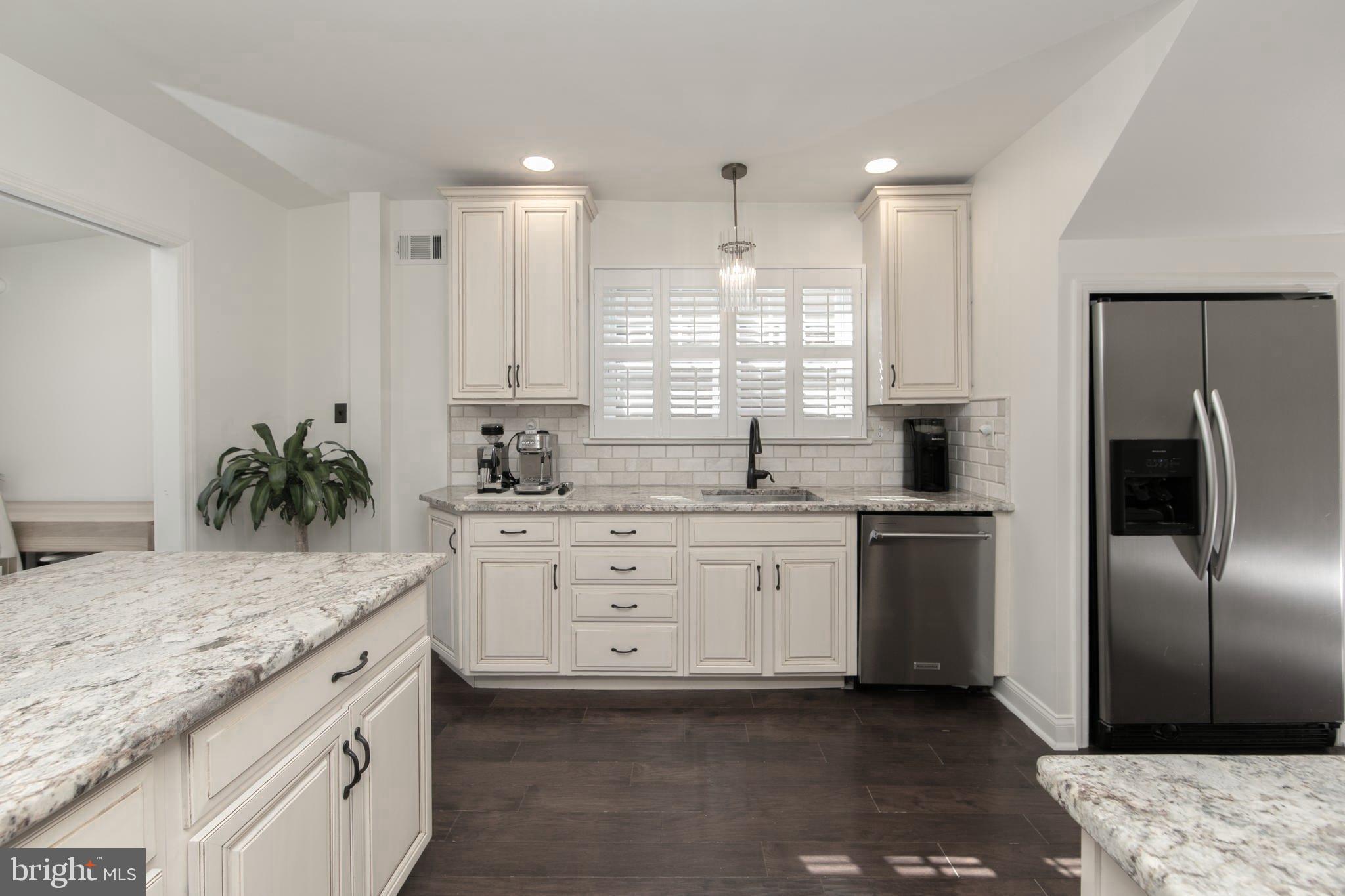 401 Spruce Street Haddonfield, NJ 08033 - Photo 15 of 40 a kitchen with granite countertop a sink stainless steel appliances and white cabinets