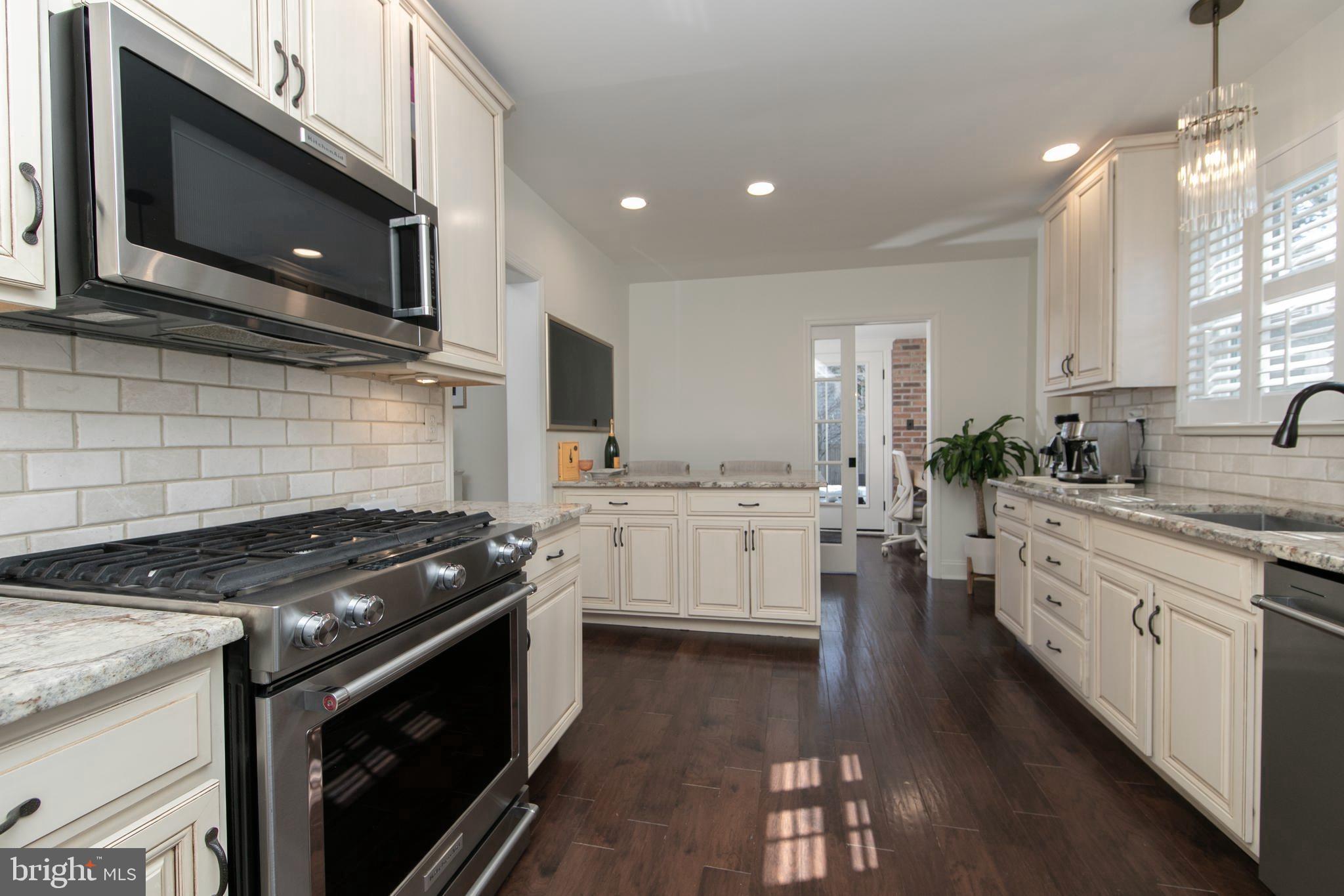 401 Spruce Street Haddonfield, NJ 08033 - Photo 18 of 40 a kitchen with stainless steel appliances kitchen island granite countertop a stove a sink and a microwave