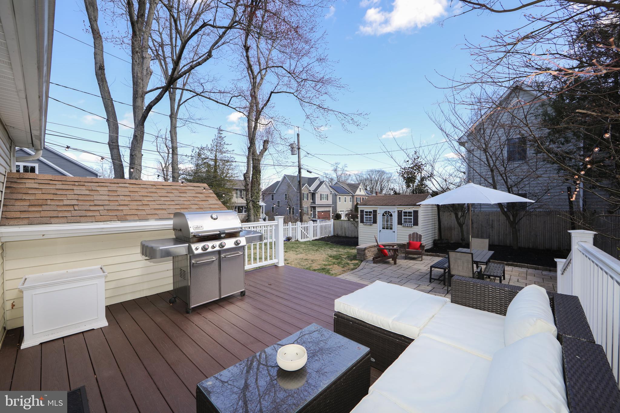 401 Spruce Street Haddonfield, NJ 08033 - Photo 33 of 40 a view of a patio with couches table and chairs under an umbrella with wooden floor